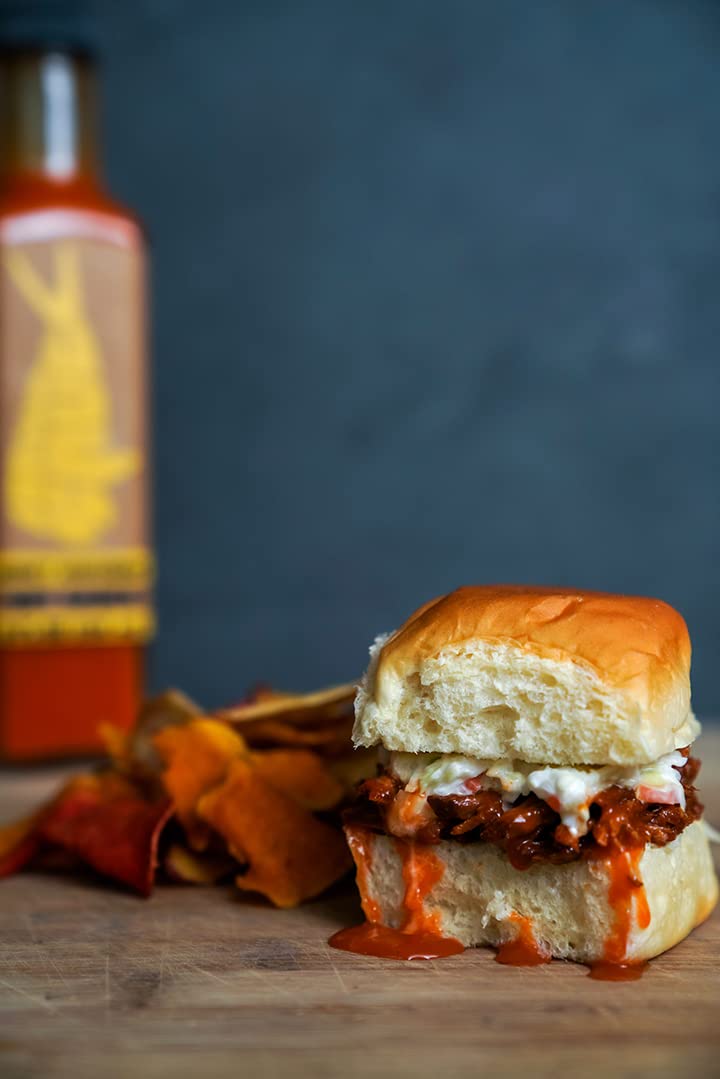 Hank Sauce Herb Infused Hot Sauce on grilled chicken for flavorful finish.