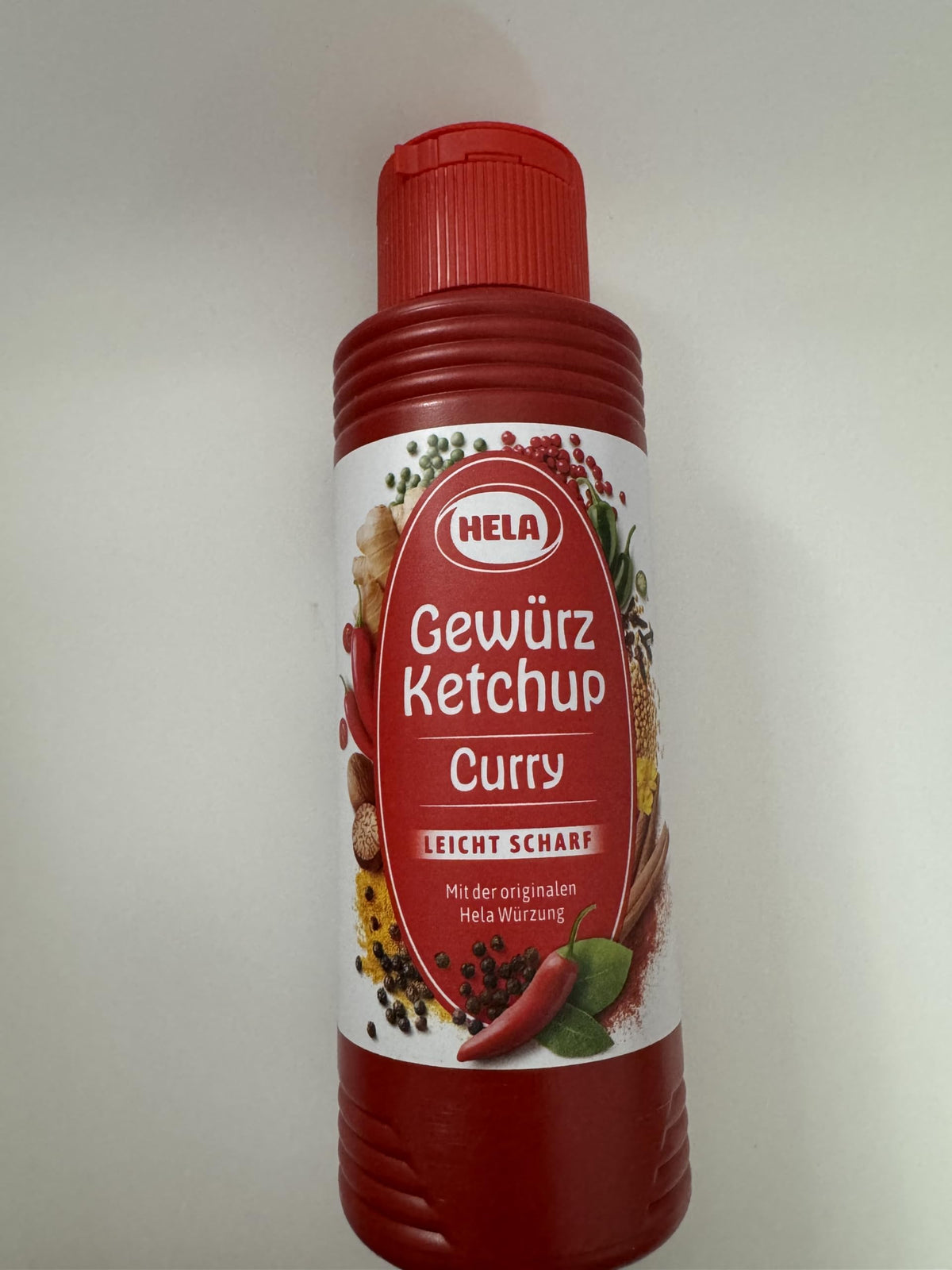 HELA Curry Gewurz Ketchup Scharf bottle pouring for burgers.