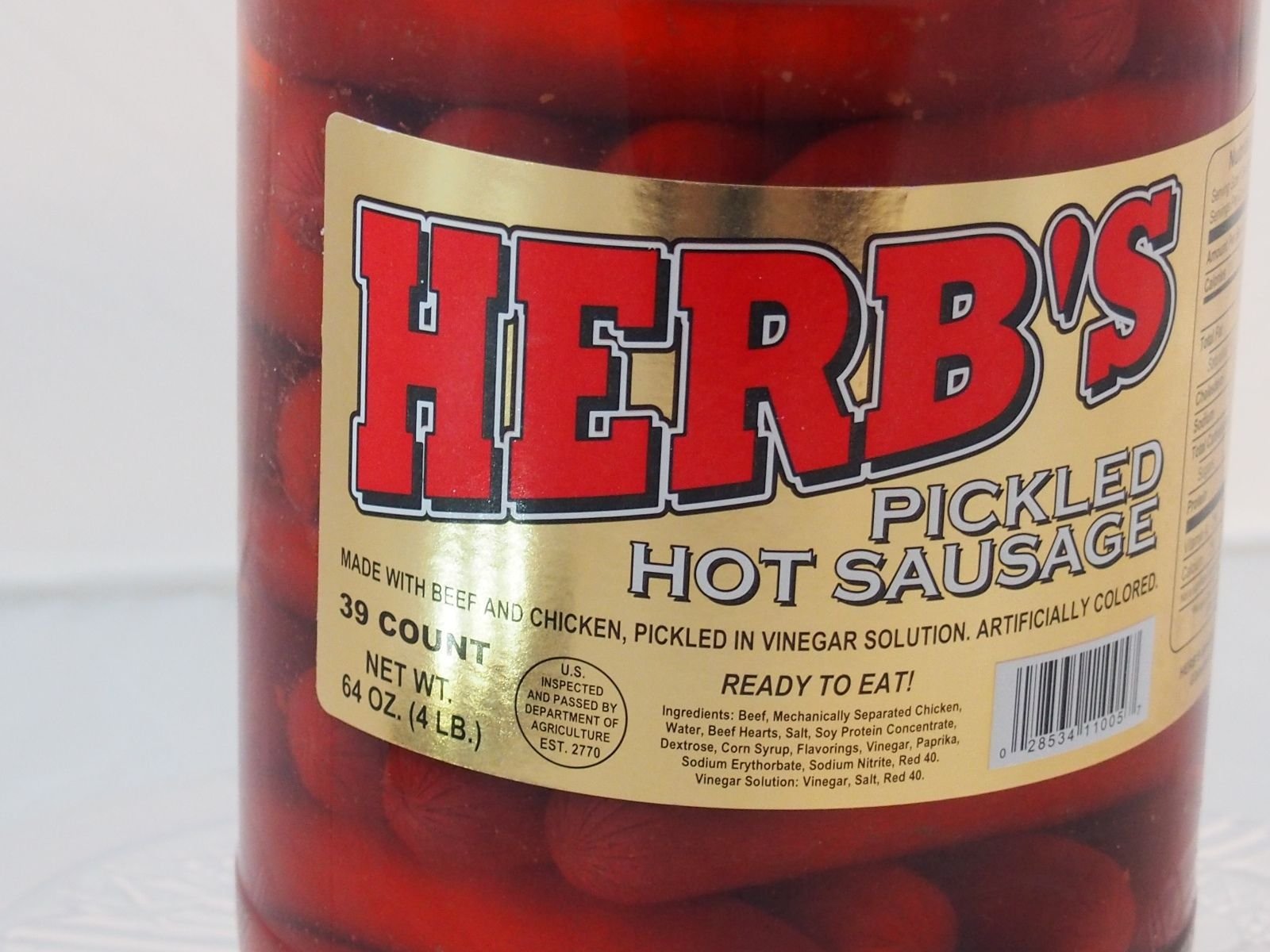 Herbs red hot pickled sausage slices close-up showing tangy crunch.