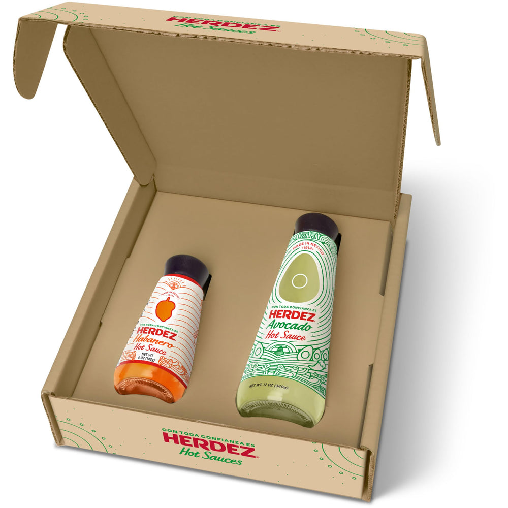 Herdez Avocado Hot Sauce 12oz bottle pouring for creamy heat in meals.