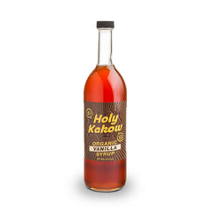 Holy Kakow Cafe Organic Vanilla Syrup bottle on counter highlights real ingredients for rich flavor.