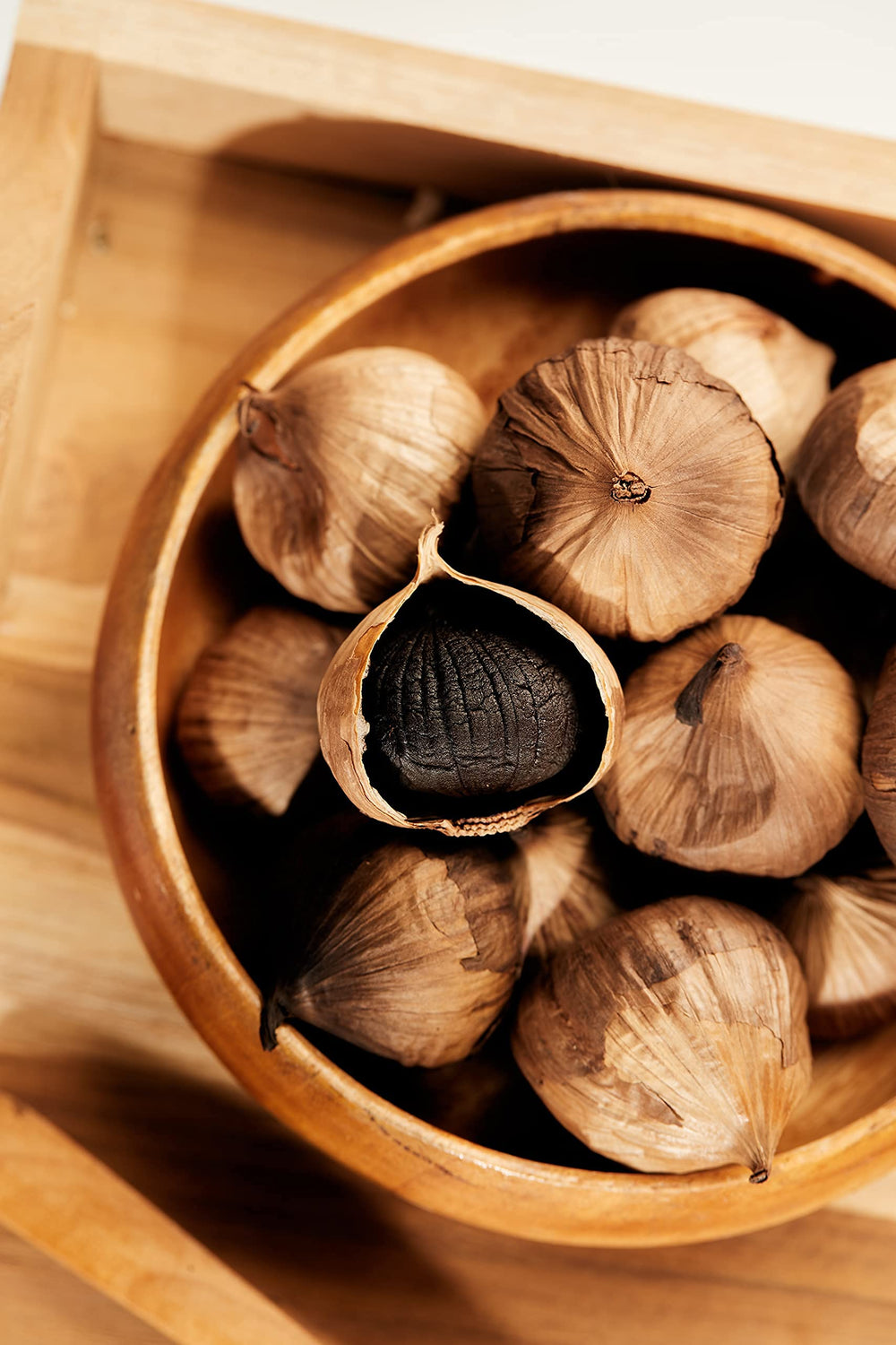 HOMTIEM Black Garlic ready-to-eat snack served with nuts and greens.