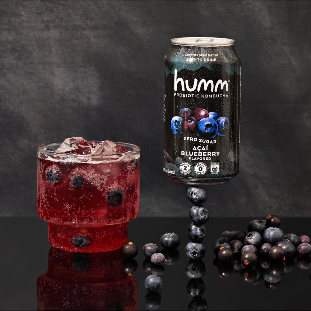 Humm pouring probiotic kombucha into a glass for on-the-go hydration.