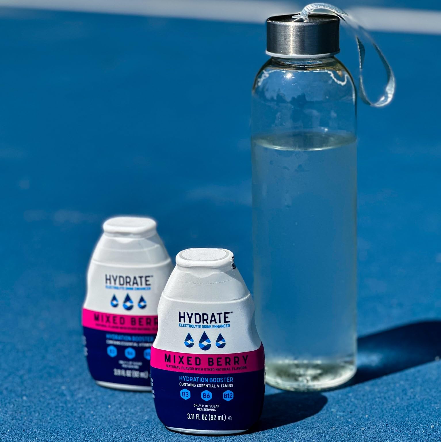 Bright hero shot of Hydrate Drops with mixed berry color in a glass.