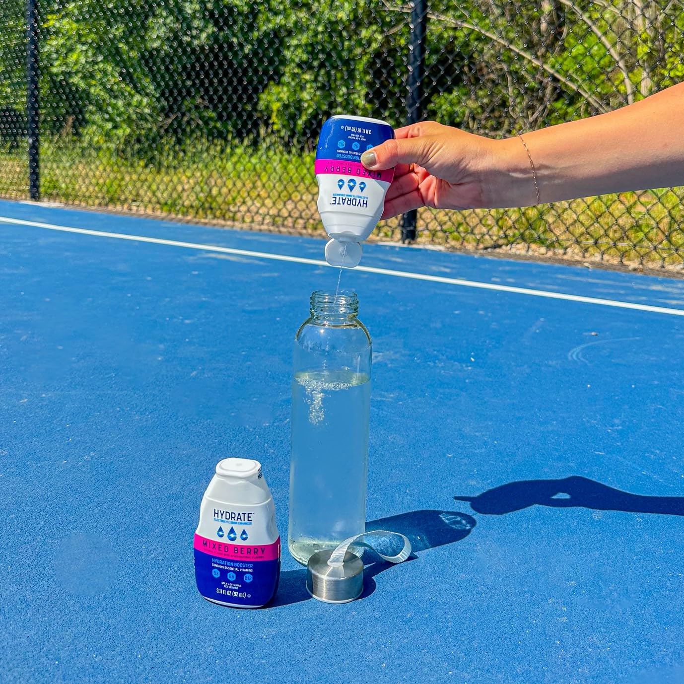 Sipping straw with berry swirl shows easy flavor infusion using Hydrate drops.