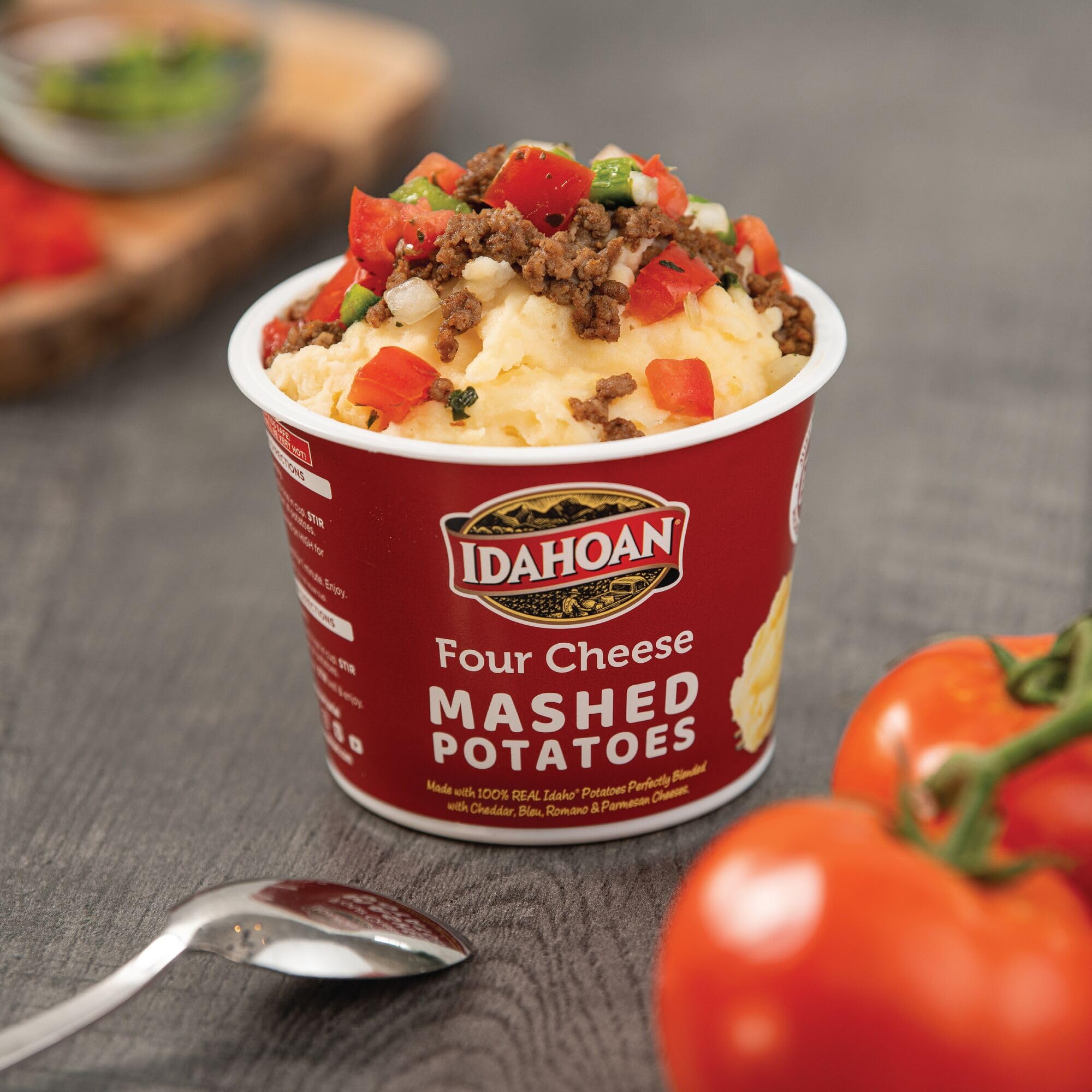 Idahoan Four Cheese Cups on a kitchen counter with ingredients nearby.