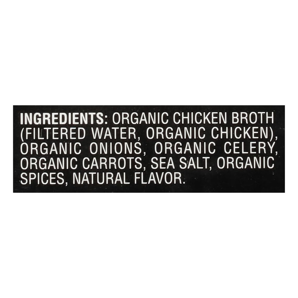 Imagine Organic Free Range Chicken Broth carton being held up to show fresh ingredients.