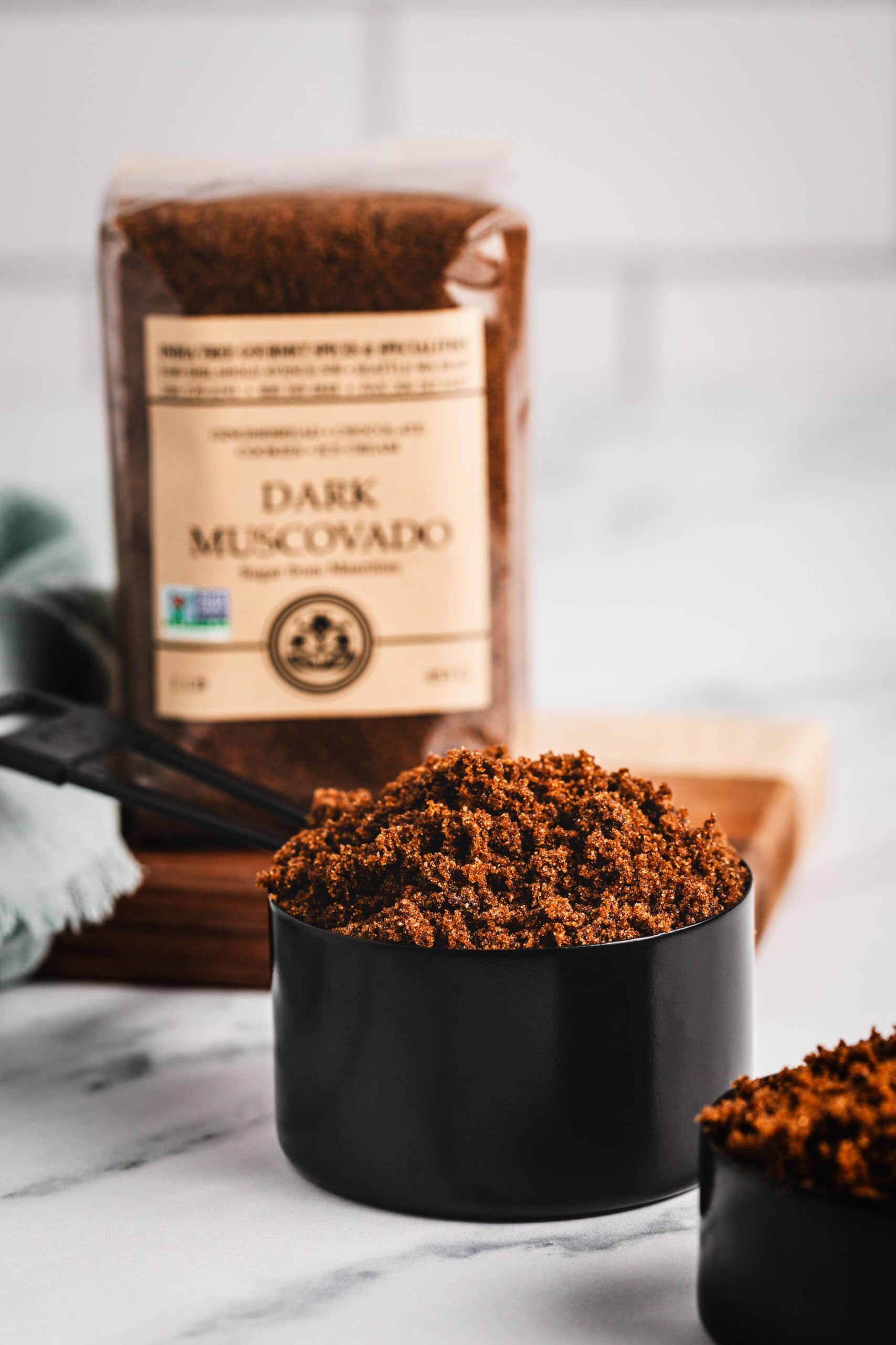 India Tree Dark Muscovado Sugar in a measuring cup supports easy 1:1 substitutions.