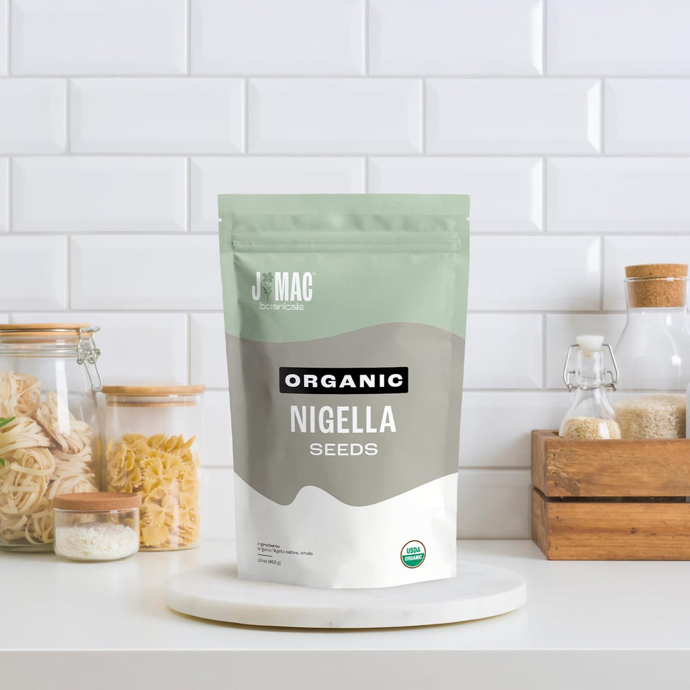 Nigella seeds on spice rack with J Mac Botanicals branding.