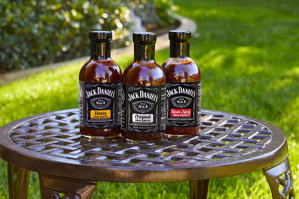 Grilling setup with brush and Jack Daniels Barbeque Sauce Sweet and Spicy glaze ready.