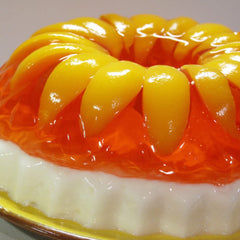 Jell-O Peach Gelatin Dessert being poured into a glass.