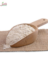 Sorghum flour being poured into a measuring cup for baking.