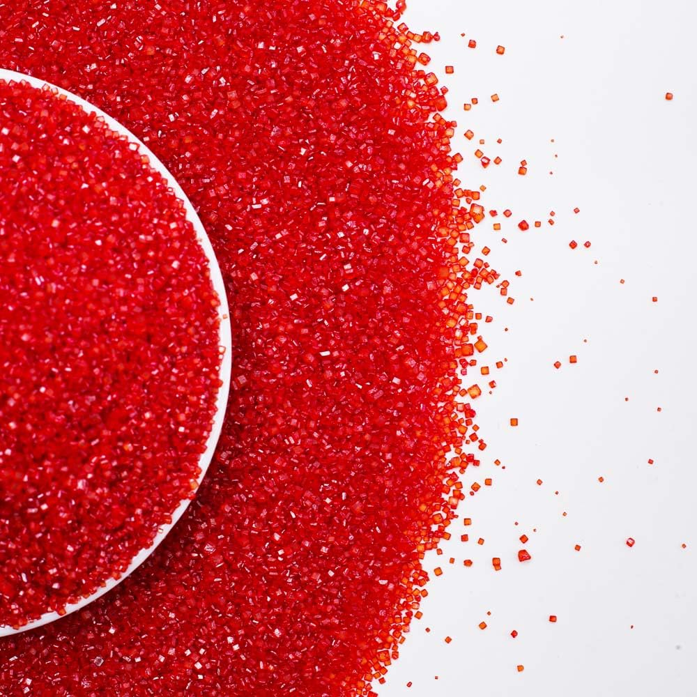 Pouring Kasvan Red Sanding Sugar crystals over a dessert for precise topping.