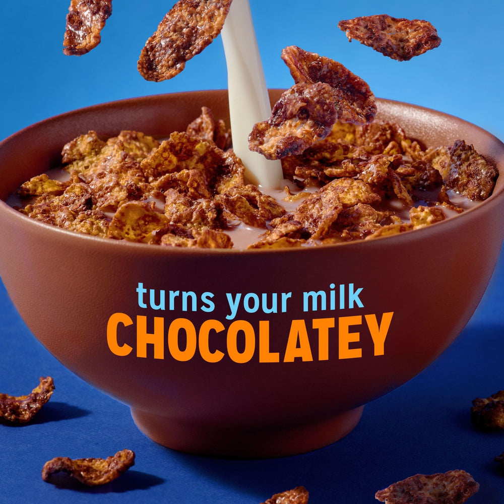 Kellogg's Frosted Flakes Chocolate Milkshake spooning flakes for a crunchy bite.