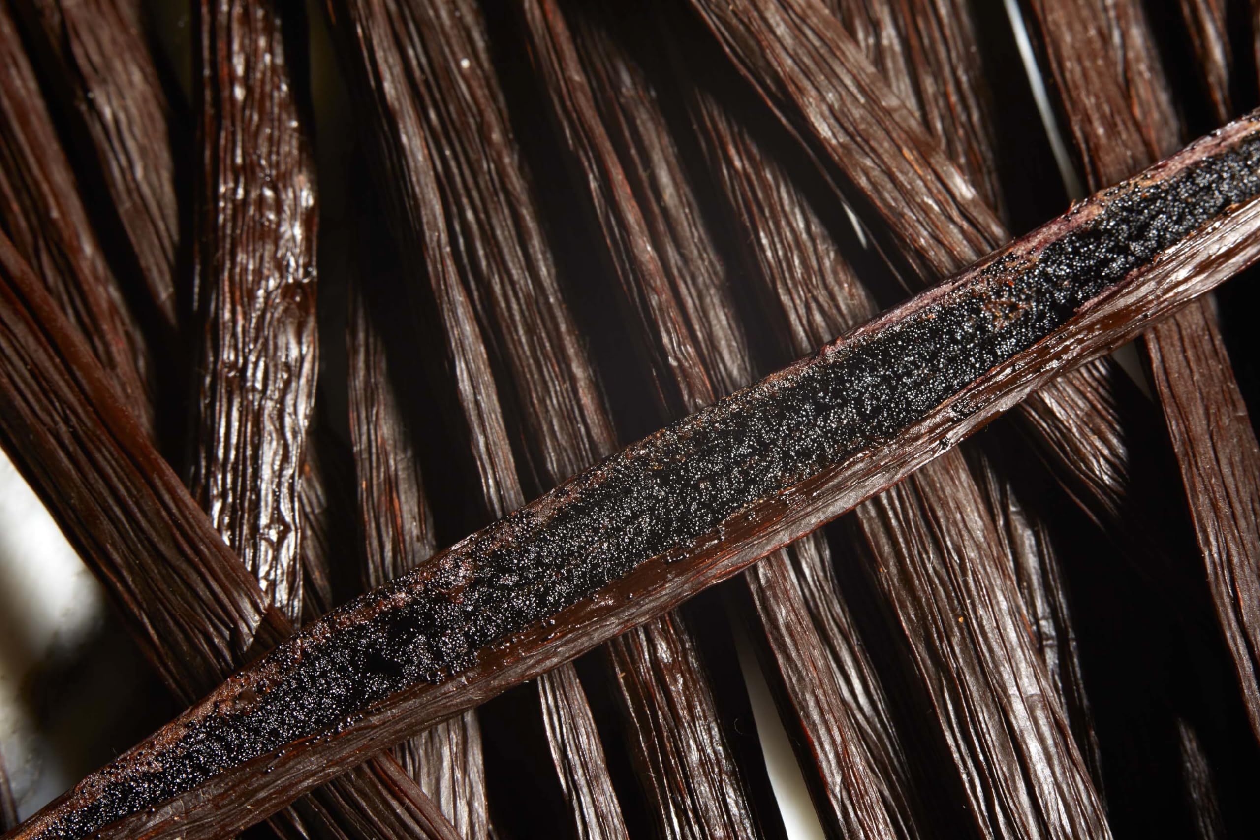 Kiddu vanilla beans split-open reveal seeds ready for scraping.