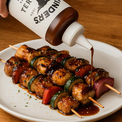 Kinder's Teriyaki glaze pour over meat, showcasing versatile marinade use.