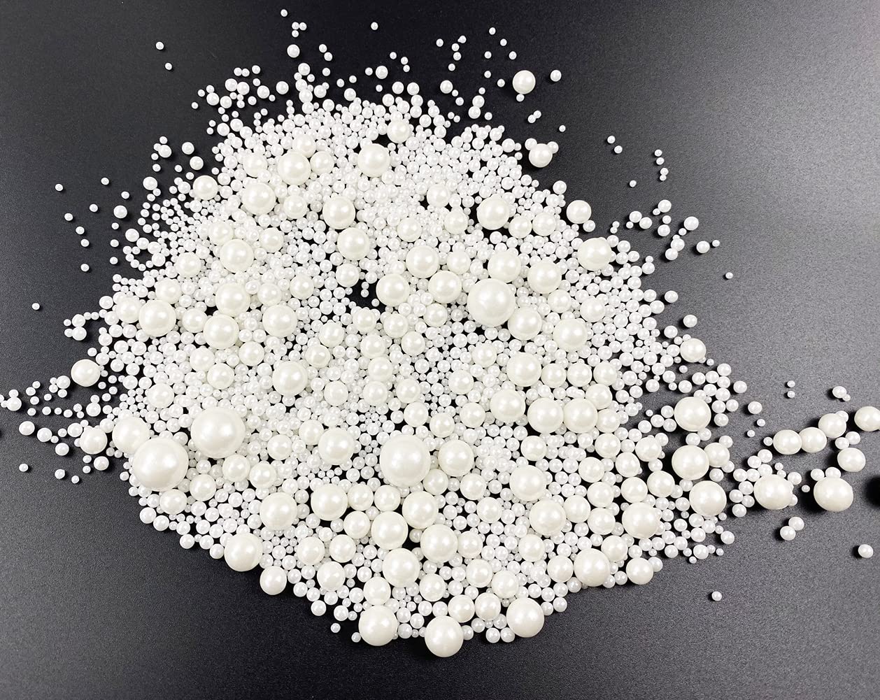 Kuting sugar pearl balls decorating cupcakes with a glossy finish