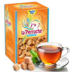 La Perruche brown sugar cubes on a spoon ready to sweeten tea.