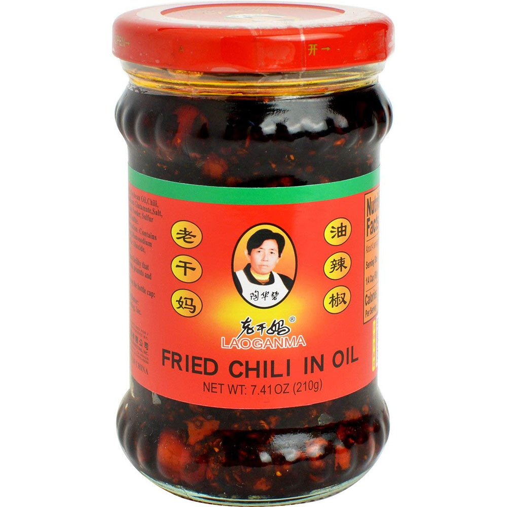 Laoganma chili sauce bottle pouring to boost stir-fry flavor and heat.