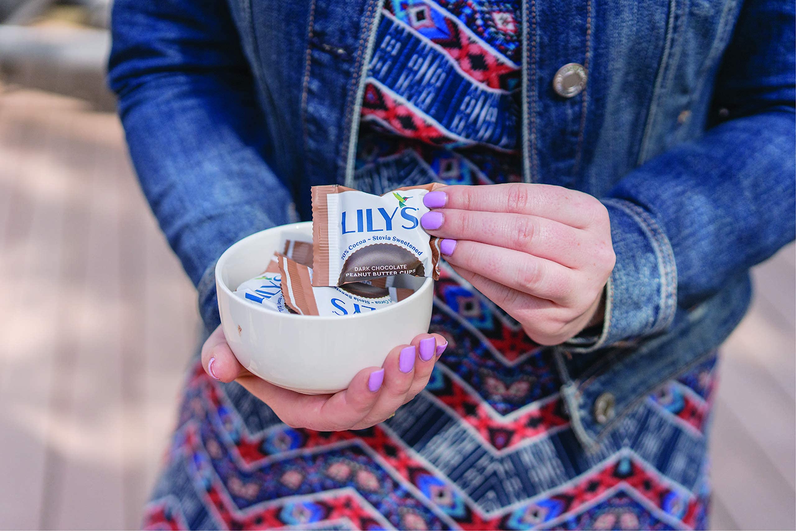 Lily's dark chocolate peanut butter cups on wood board, fair trade branding.