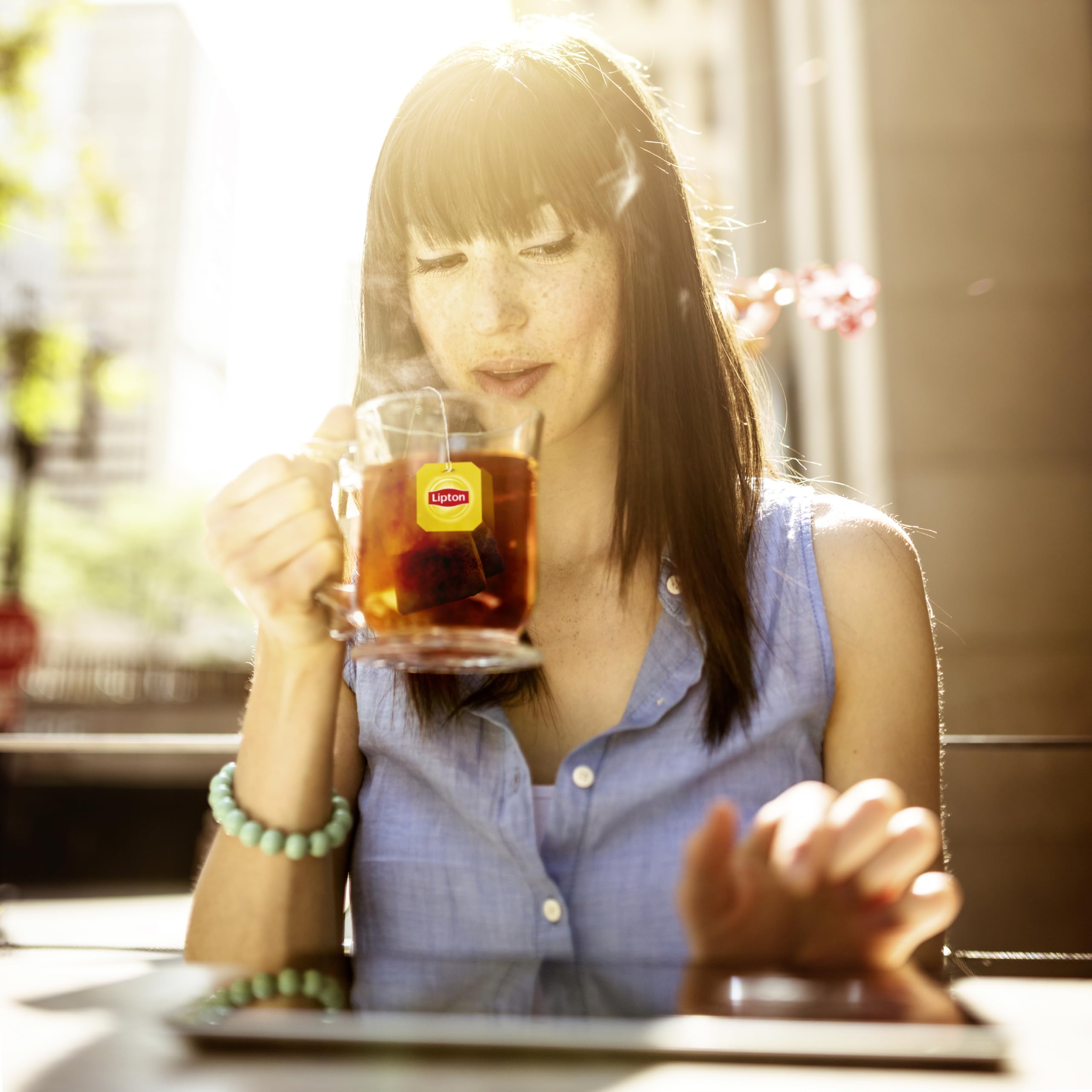 Pouring Lipton iced tea from a pitcher, vibrant amber color.