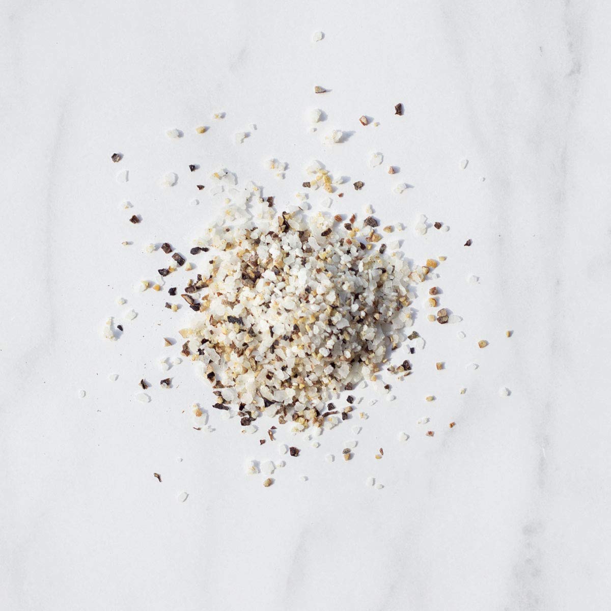 Livia's Salt Pepper Garlic Seasoning grinder shown in action for peppery crusts.