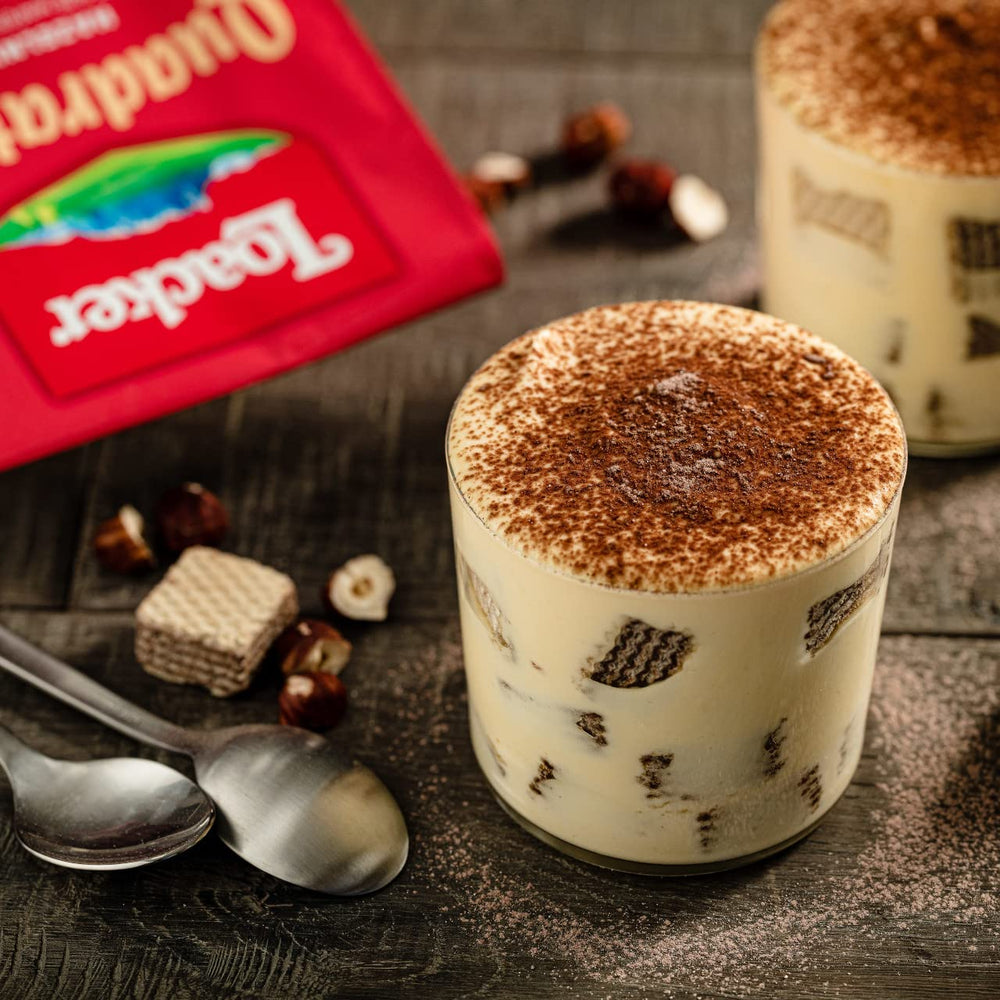 Loacker Quadratini tiramisu collection beside coffee, suggesting a cozy break.