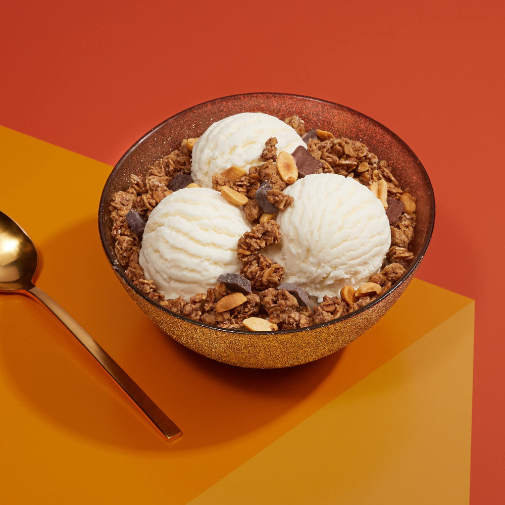 Love Crunch granola pouch poured over berries, a flavorful morning ritual.