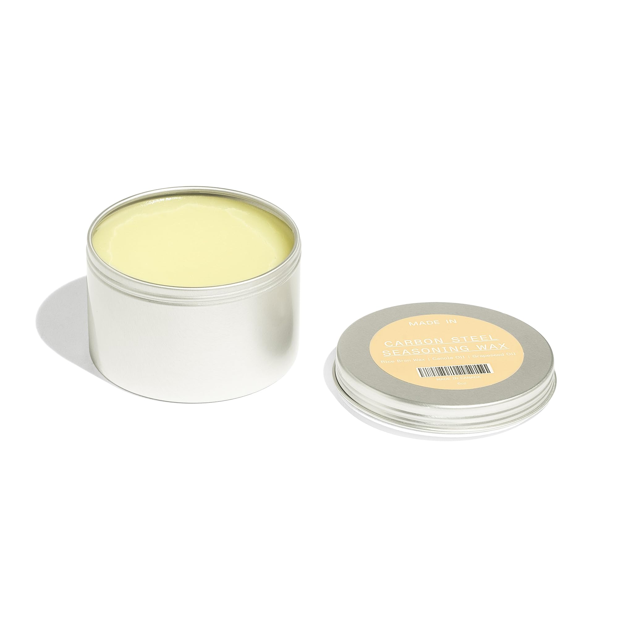 Made In seasoning wax jar open reveals oils blend ideal for sealing cookware.
