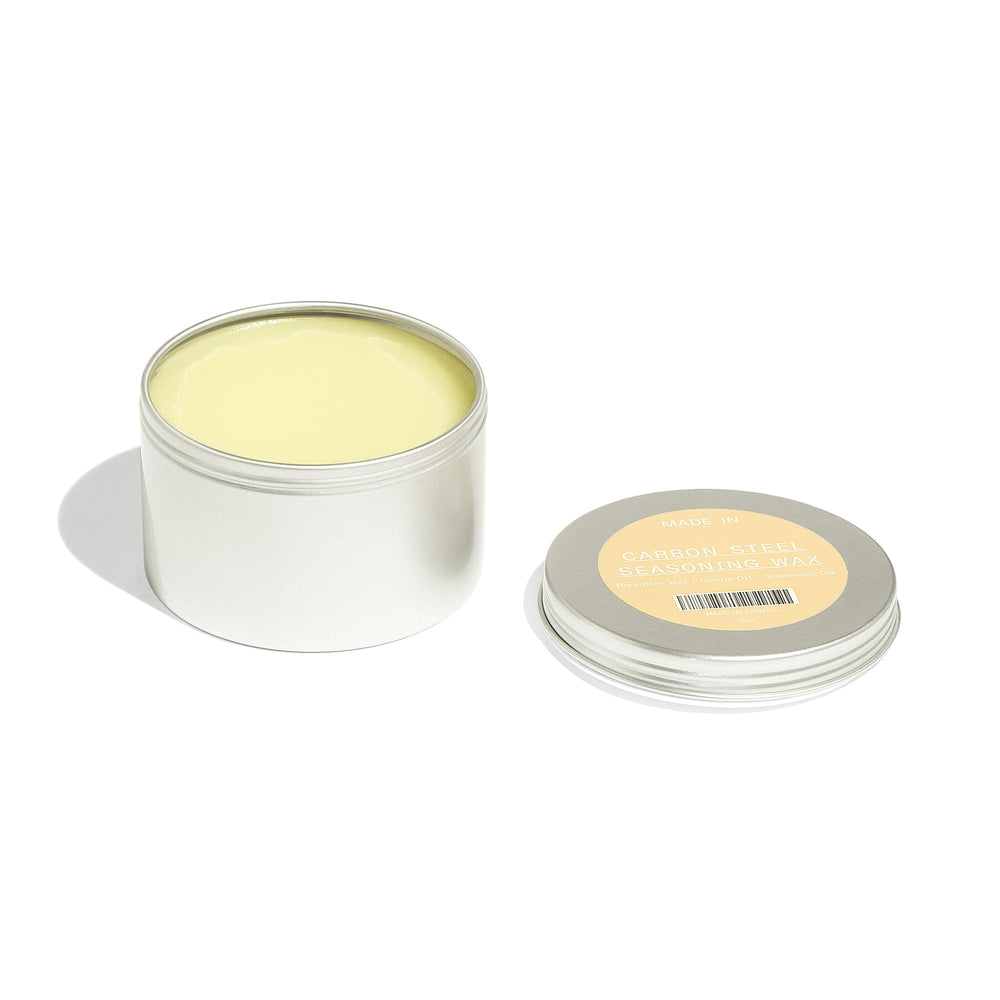 Made In seasoning wax jar open reveals oils blend ideal for sealing cookware.