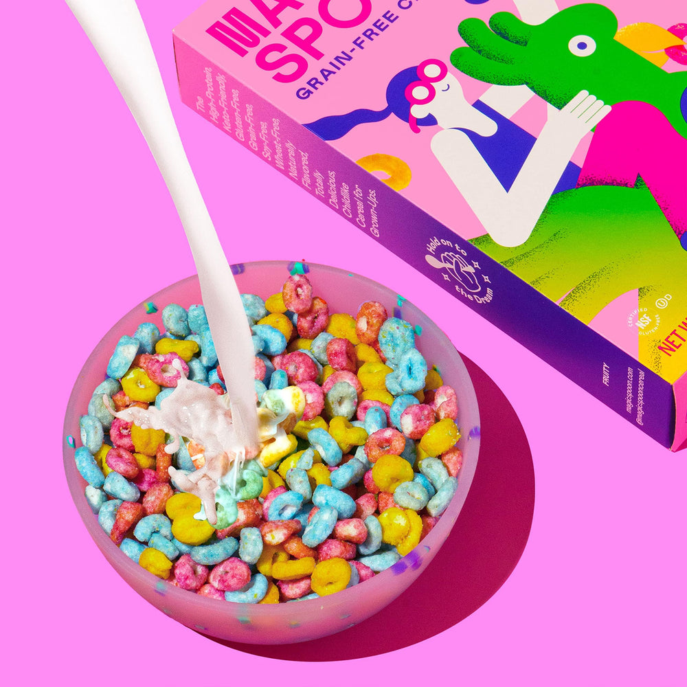 Magic Spoon Fruity cereal scoop beside milk suggests crunchy, satisfying breakfast.