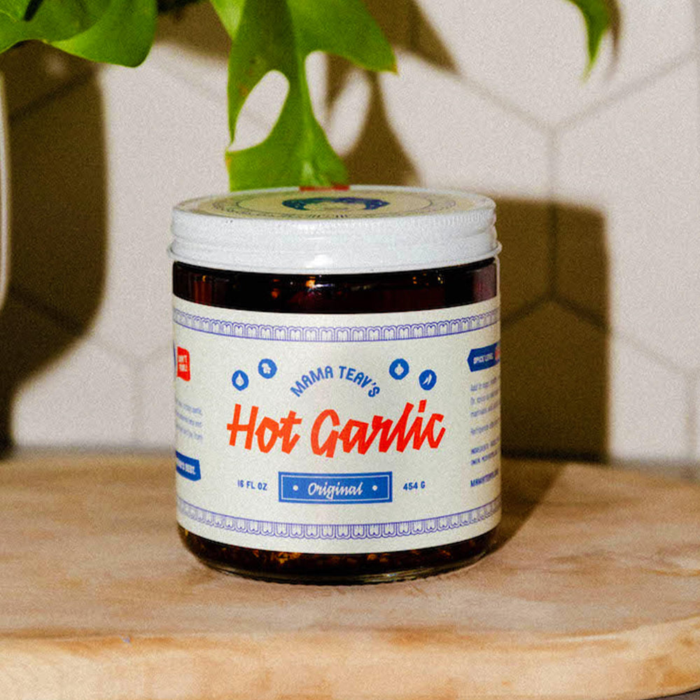 Mama Teav's Hot Garlic Chili Crisp being poured over a dish to show crispy garlic