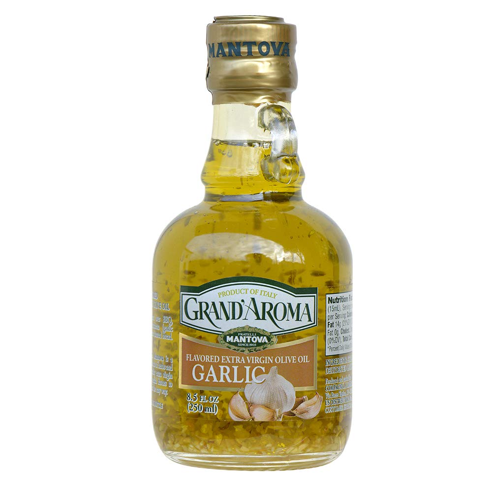 Mantova Garlic Grand'Aroma olive oil bottle pouring over pasta for bright Italian flavor.