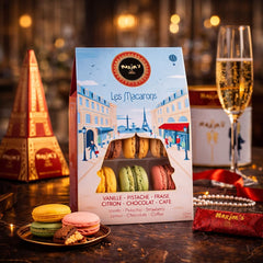 Maxim's de Paris macarons on a plate inviting tasting of vanilla, coffee, chocolate and pistachio.