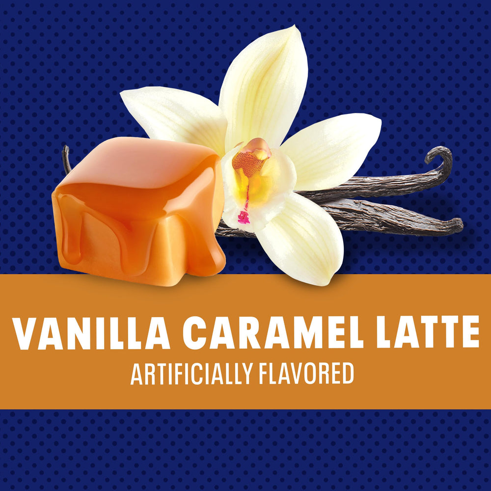 Scooping Maxwell House mix into hot water to create a creamy vanilla caramel latte