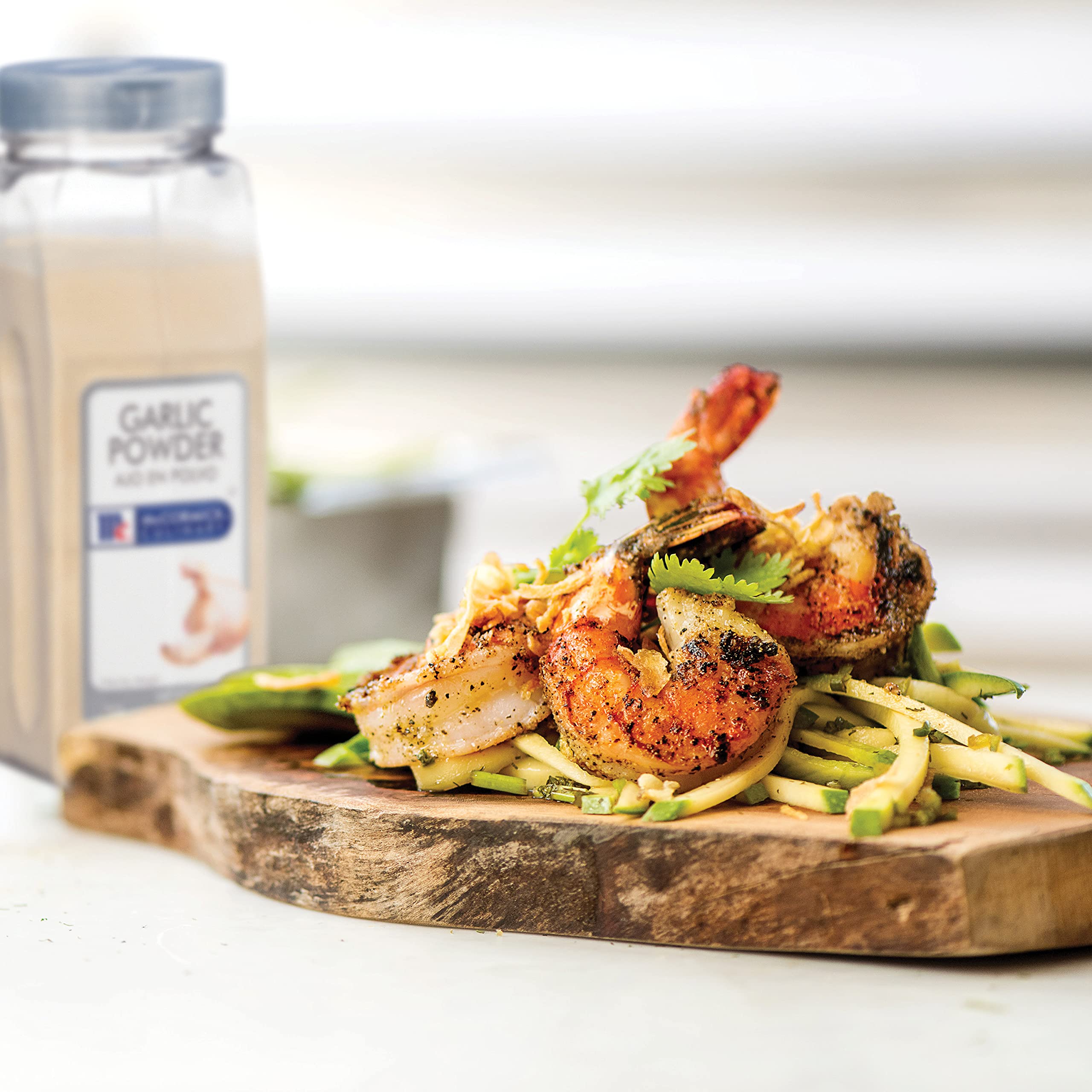 McCormick Culinary Garlic Powder canister paired with thyme and marjoram for flavor boost.