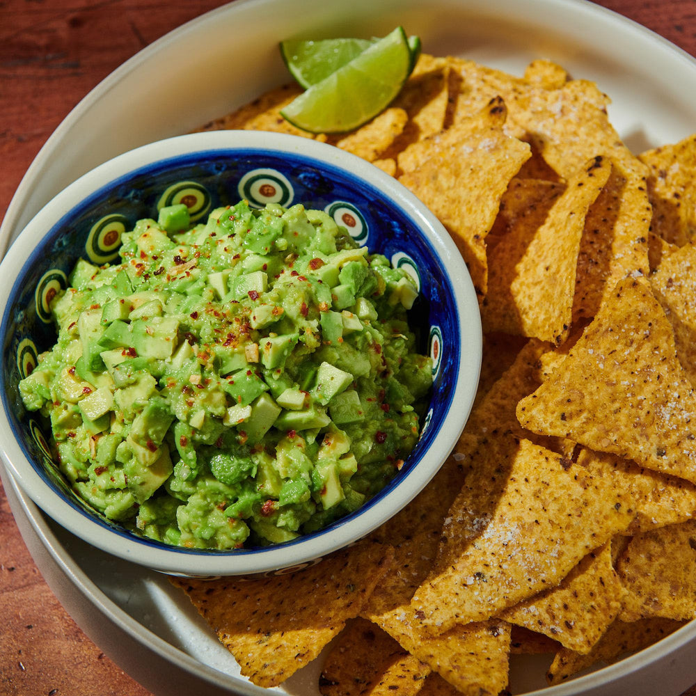 Sprinkling McCormick Culinary Guacamole and More Seasoning for easy flavor boost