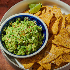 Sprinkling McCormick Culinary Guacamole and More Seasoning for easy flavor boost