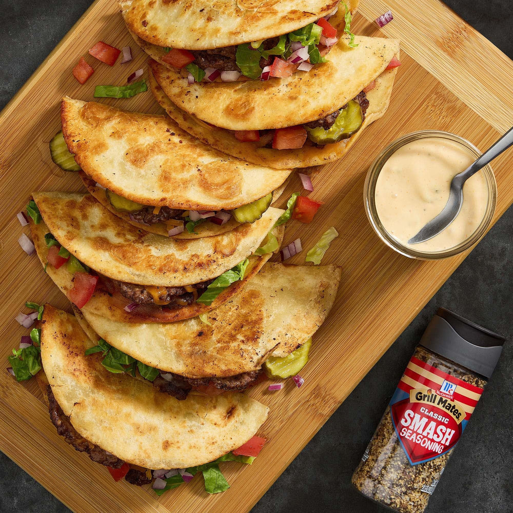 Pouring McCormick Grill Mates Classic Smash Seasoning from the shaker.