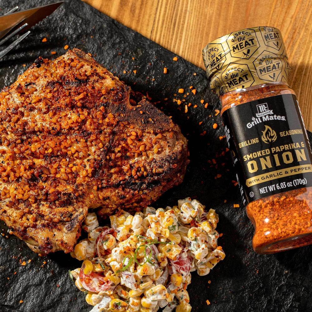 Seasoning shaker on a hot grill with grilled meat
