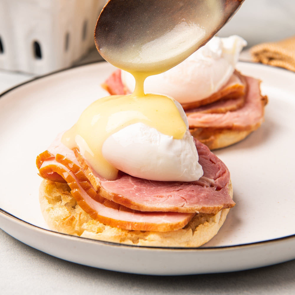McCormick Hollandaise sauce mix poured over Eggs Benedict for brunch flair
