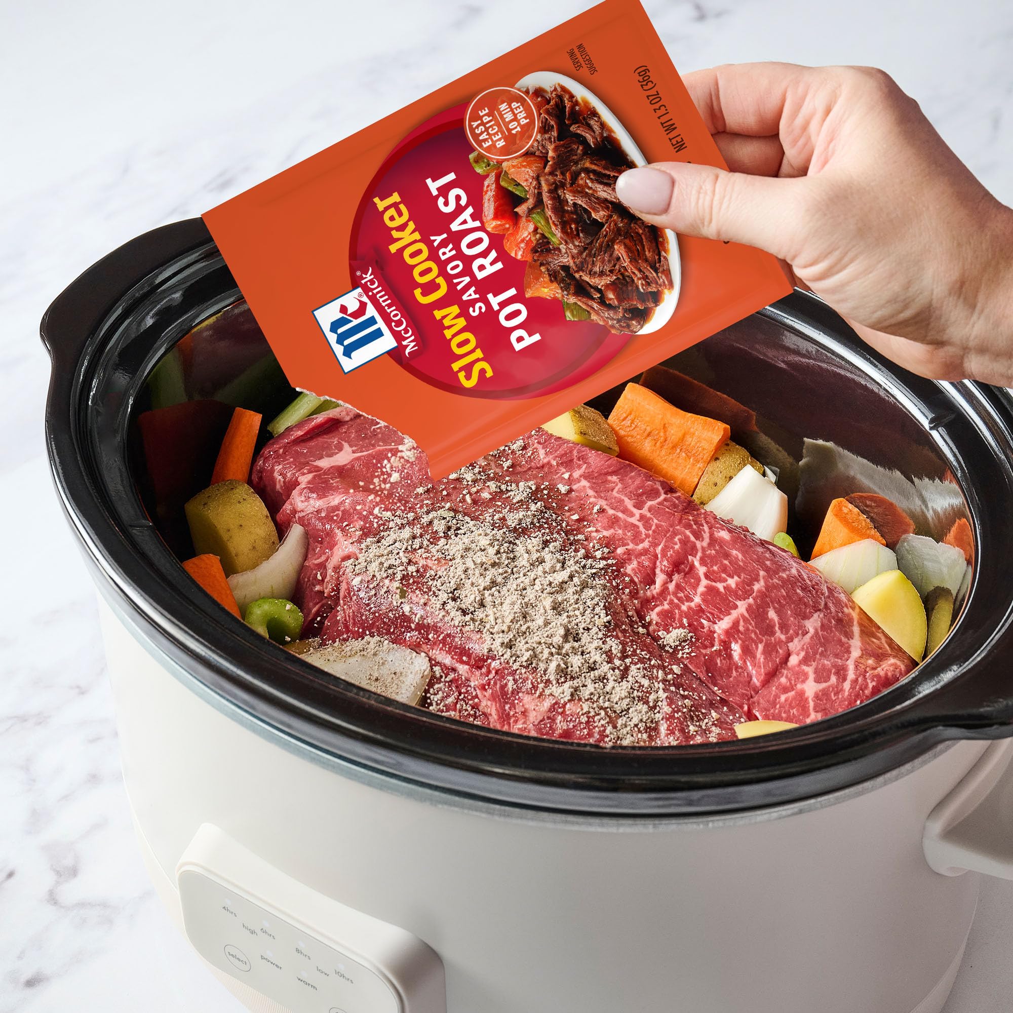 Measuring spoon with McCormick pot roast mix and water ready to combine.