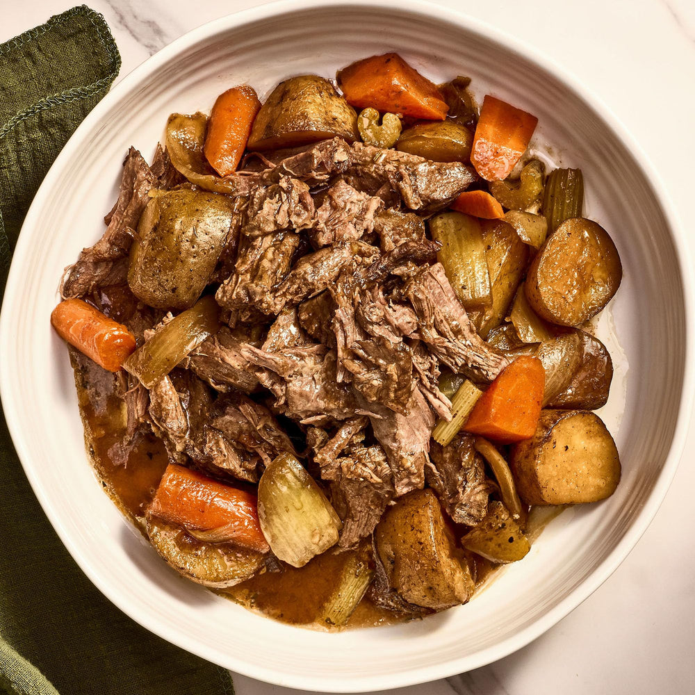 Plate of pot roast with potatoes and carrots seasoned with McCormick mix.