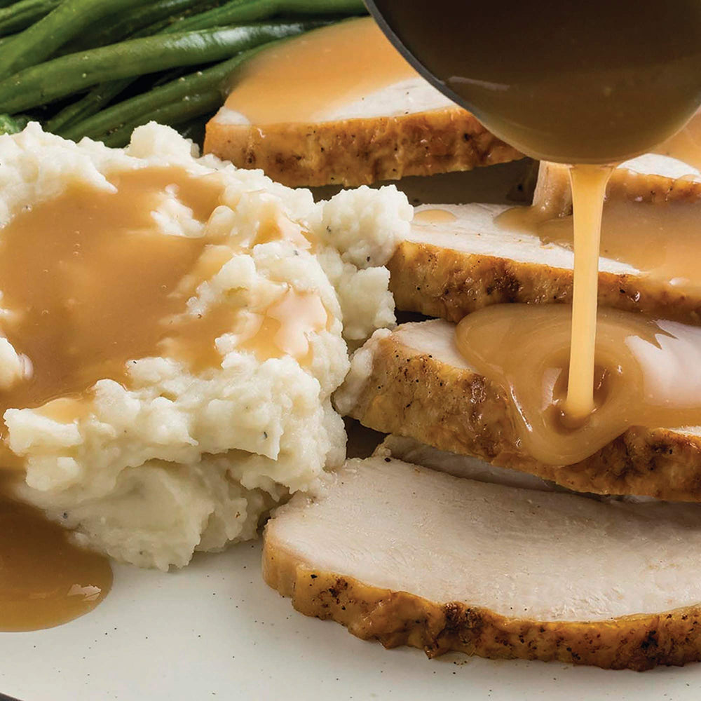 Warm kitchen scene featuring McCormick Premium Gravy in action.