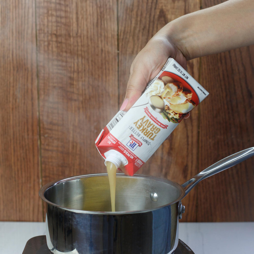 Pouring McCormick Turkey Gravy over a hot turkey sandwich enhances flavor.