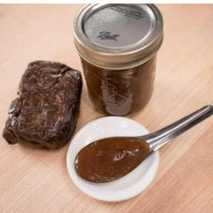 Mekoman tamarind paste bottle pour showing smooth seedless paste ready to mix