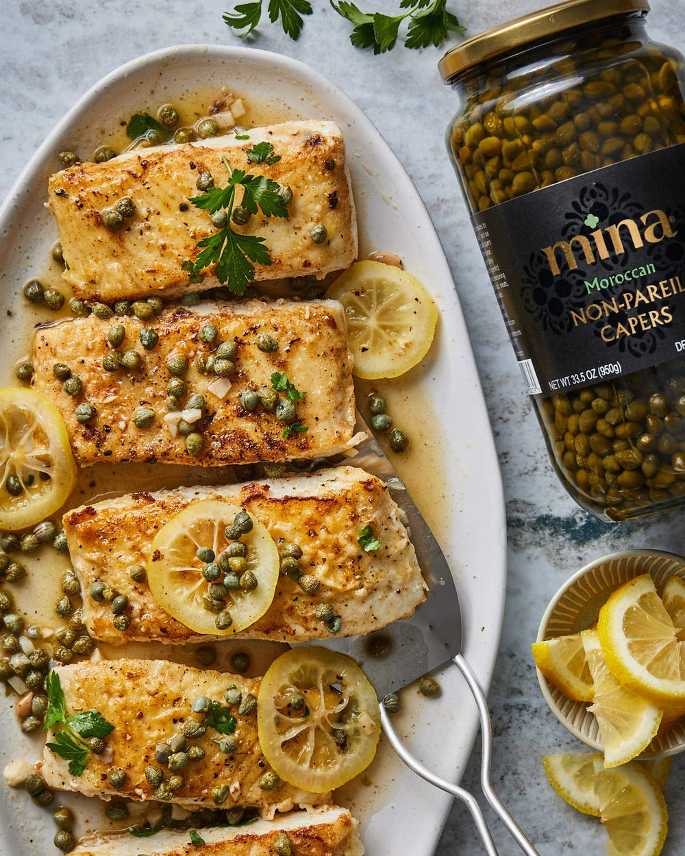 Mina Capers Non Pareil jar in kitchen with herbs and oil