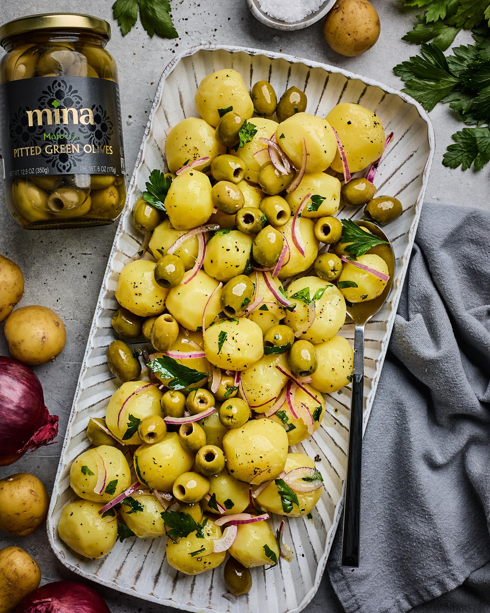 Mina Green Olives Pitted on snack plate, keto-friendly, low-calorie snack.
