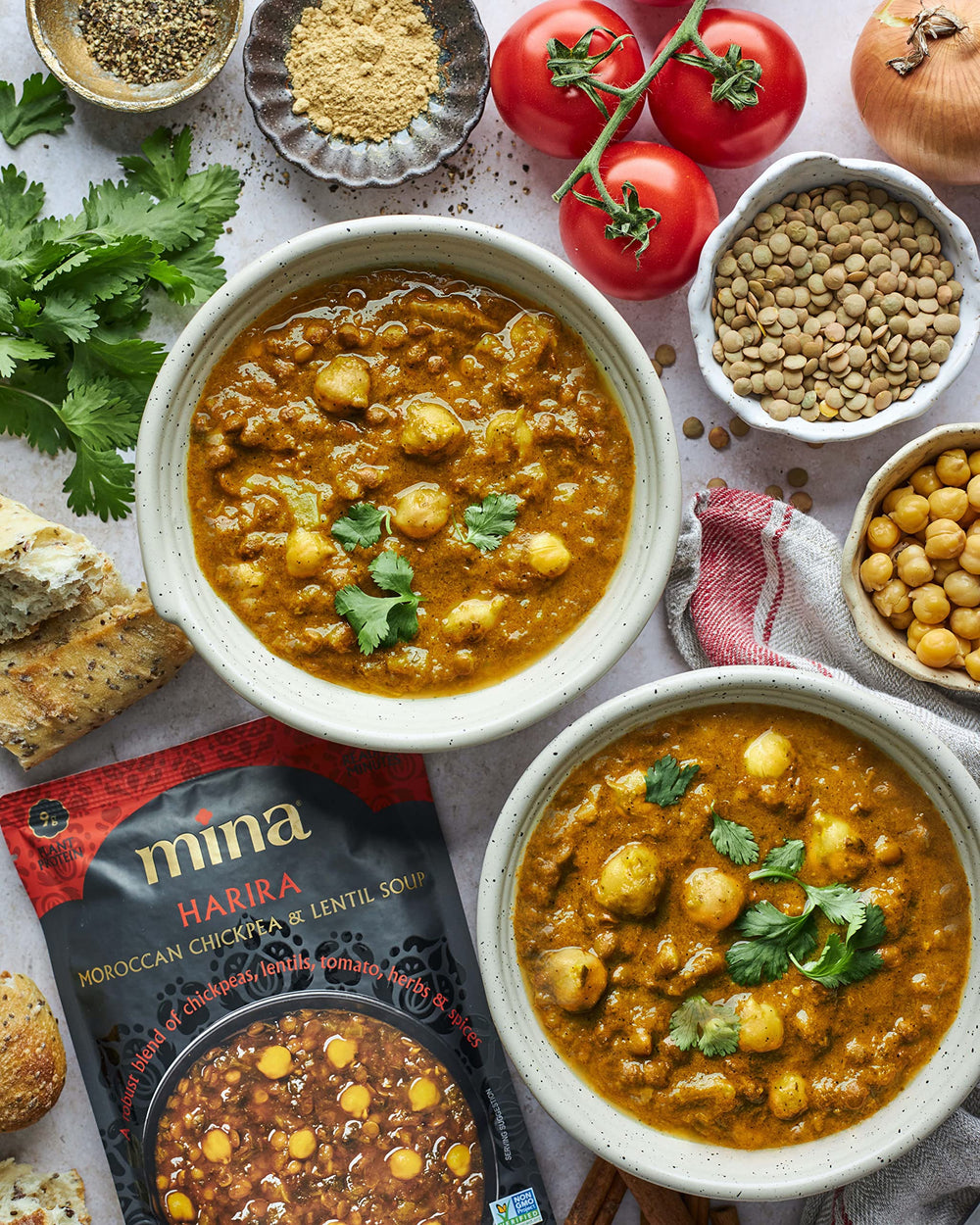 Mina Harira soup spoon dipping into a hearty chickpea-lentil mix.