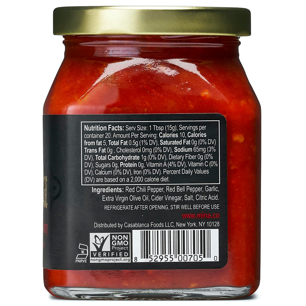 Mina Harissa hot sauce being poured for balanced heat on wings and eggs.